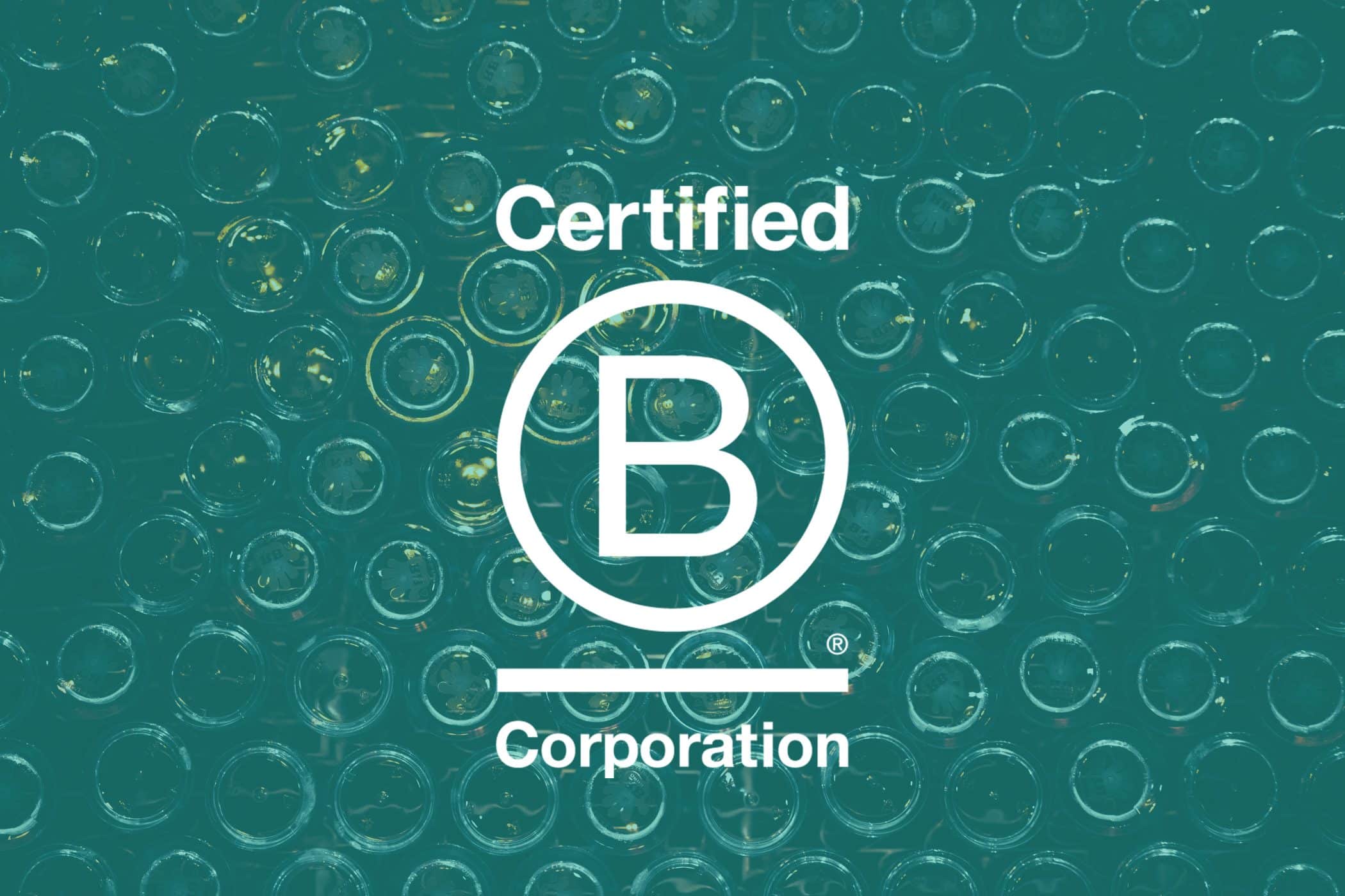 Certified B Corporation logo over a background of stacked glass bottles.